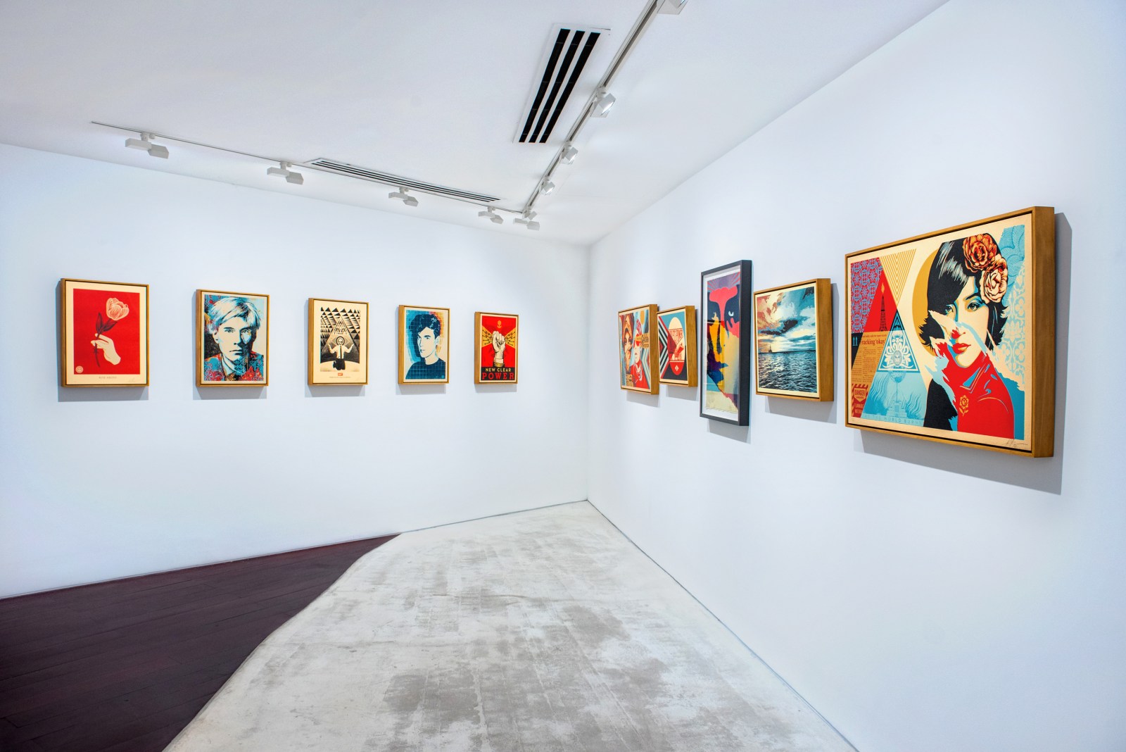 An art gallery wall displaying various pop art prints, including portraits of Andy Warhol and other figures, in vibrant…