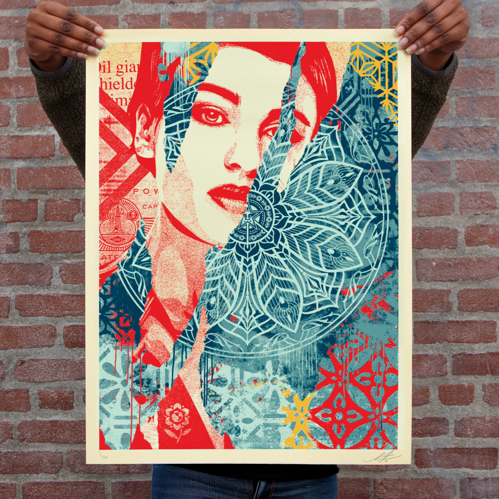 A person holding a colorful print featuring a woman's face partially obscured by geometric patterns and text.