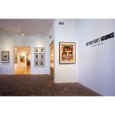 Art gallery with brick floor and white walls, featuring a large framed artwork and text "SHEPARD FAIREY / ICONS NOV 18 - DEC…